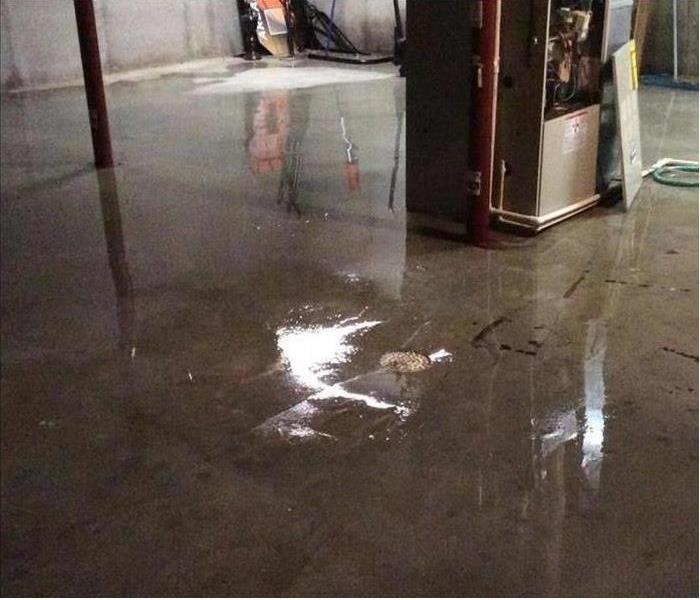 water reflecting off basement floor, furnace in photo