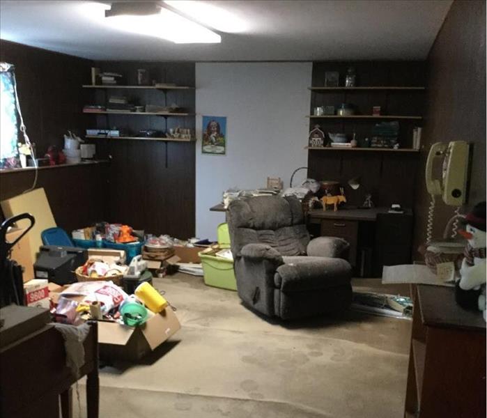 Basement with recliner and items in boxes on carpet
