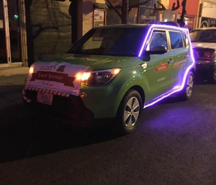 Green SERVPRO car with purple lights on it