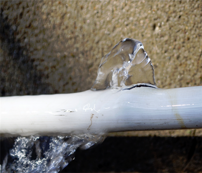 a broken white pipe with water leaking from it
