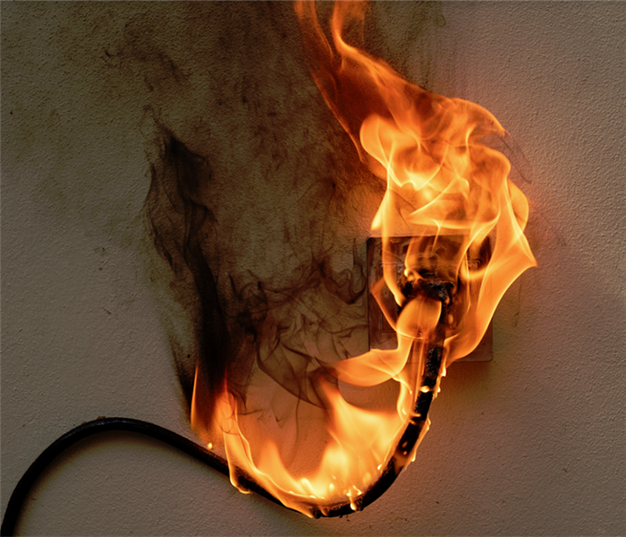 a plug in a wall that is on fire