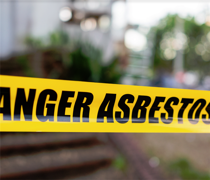 yellow caution tape that says danger asbestos