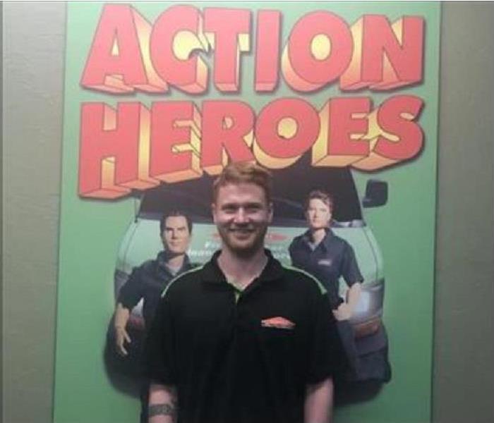 SERVPRO tech standing in front of Action Heroes picture
